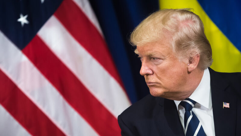 Donald Trump with an American flag behind him.
